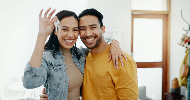 Young couple with keys outside their new home